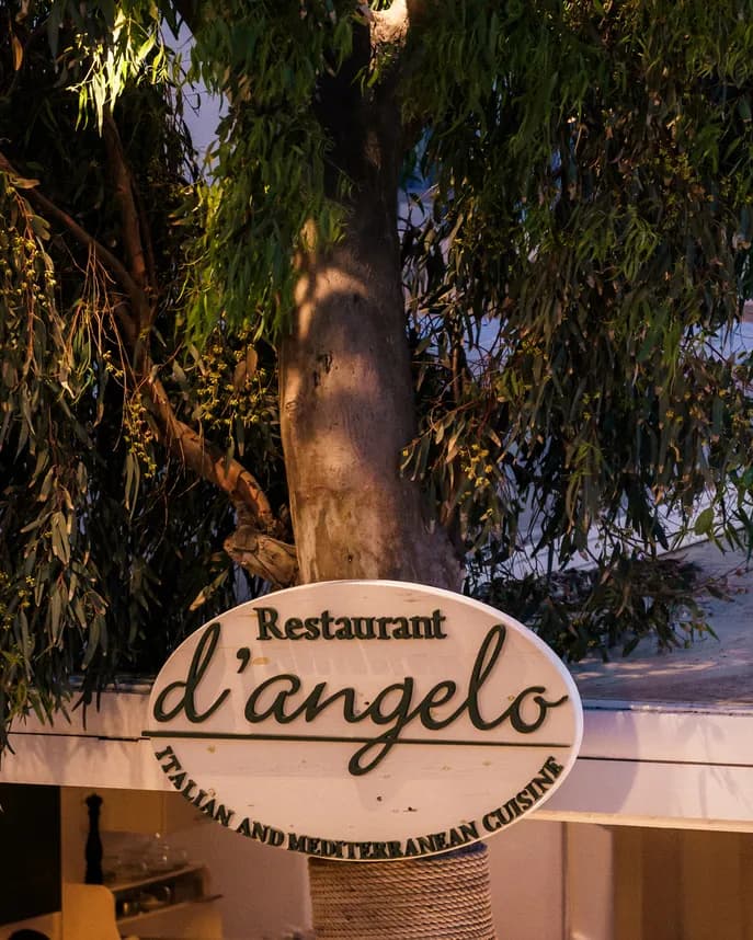 d'angelo restaurant sign under the eucalyptus tree in Mykonos Town